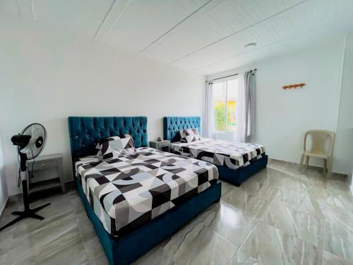Tauramena的住宿－Hotel Campestre Morichal，一间卧室设有两张床和窗户。