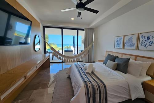 um quarto com uma cama grande e uma ventoinha de tecto em Turena depto. frente a la playa em Telchac Puerto