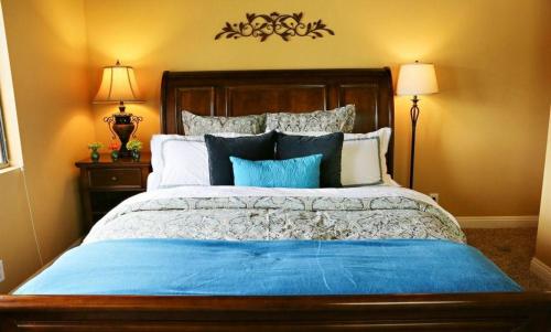 um quarto com uma cama grande com lençóis e almofadas azuis em Destination #20 em Anaheim
