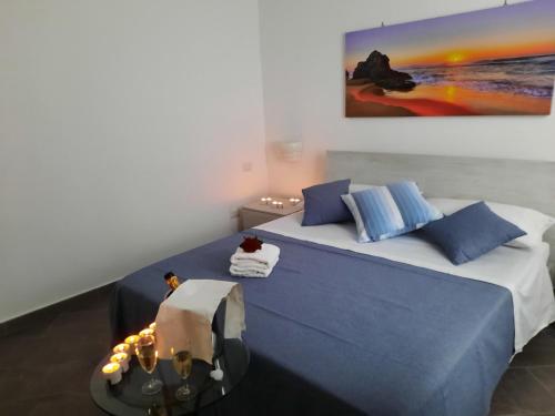 Un dormitorio con una cama azul y una mesa en giuchi home casa vacanze, en Avola
