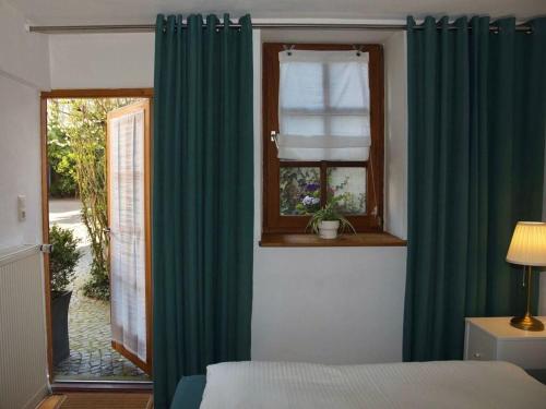 een slaapkamer met een bed en een raam met groene gordijnen bij Nice apartment in Weilmünster in Weilmünster