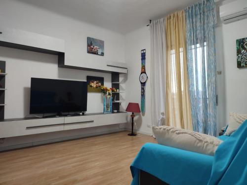 sala de estar con TV y sofá azul en ETRA Casa Vacanza, en Taranto