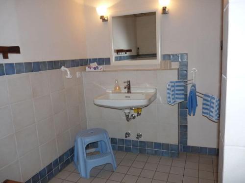 a bathroom with a sink and a blue stool at at the organic farm Angus-Hof in Stakendorf
