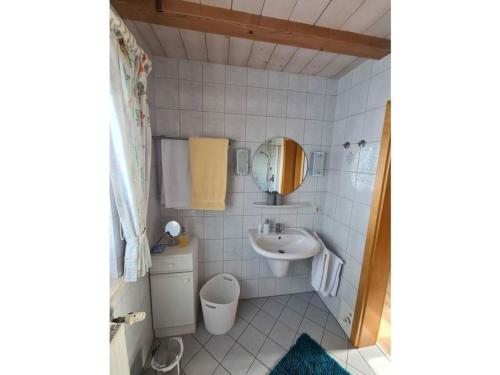 uma pequena casa de banho com um lavatório e um espelho em Holiday apartment Küber em Altusried
