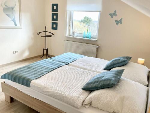 Un dormitorio con una cama con almohadas y una ventana. en Holiday apartment SonnenNest, en Braunau