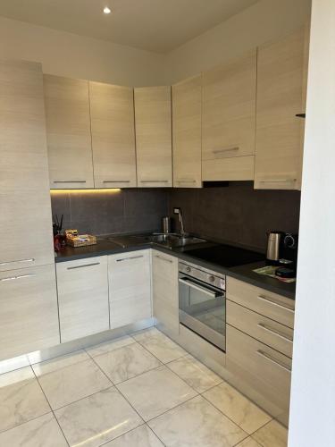 una cucina con armadietti bianchi e ripiani neri di Isola Apartment a Milano