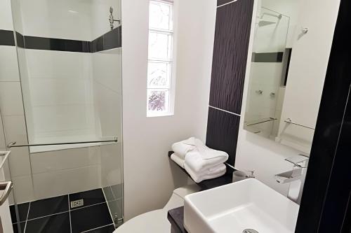 uma casa de banho branca com um lavatório e um WC em 404 Moderno Aparta-Suite en Versalles Tipo Loft - Cali Tower Suites & Lofts em Cali