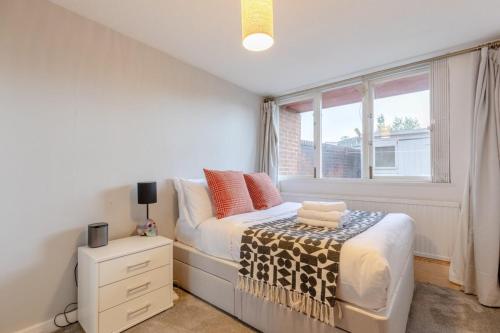 a bedroom with a bed and a window at Stunning 1BD Flat w Garden area Kentish Town! in London