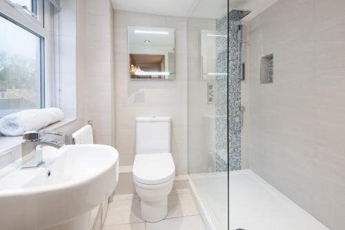 a bathroom with a toilet and a sink and a shower at Castle Retreat - luxury apartment opposite Alnwick Castle in Alnwick