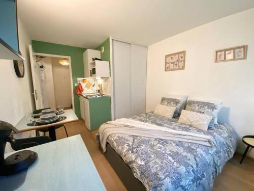 - une petite chambre avec un lit, un bureau et une table dans l'établissement L'Hermès - Wifi - Parking - Netflix, à Villeurbanne