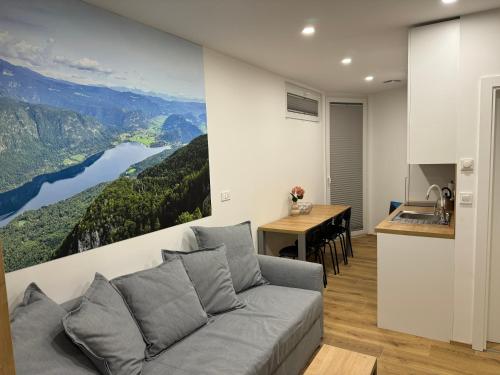uma sala de estar com um sofá e uma cozinha em Apartma Tisa Bohinj em Bohinj