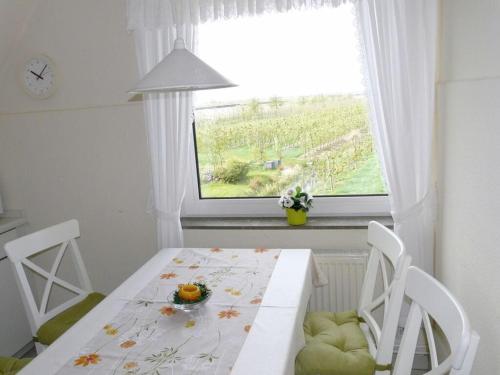 uma sala de jantar com uma mesa e 2 cadeiras e uma janela em Holiday apartment Am Elbdeich 2 em Jork