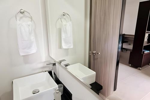 a white bathroom with a sink and a mirror at 405 Moderno Aparta-Suite en Versalles Tipo Loft - Cali Tower Suites & Lofts in Cali