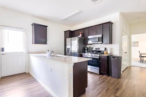 a kitchen with black cabinets and a white counter top at Contemporary Austin Home Near Downtown & Airport in Austin