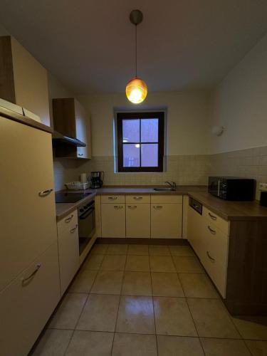 eine Küche mit weißen Schränken und einem Fenster in der Unterkunft Merseburg 2 Zimmer Apartment mit guter Ausstattung in Merseburg