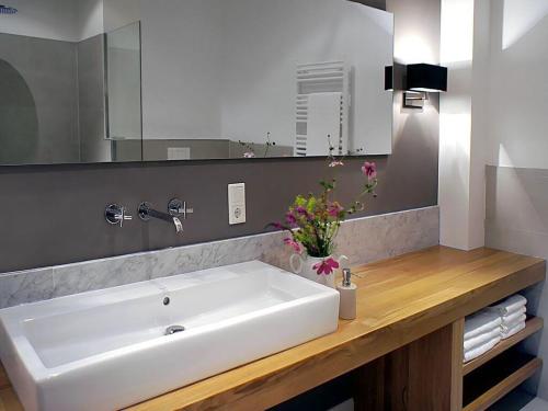 een badkamer met een witte wastafel en een spiegel bij Appealing apartment in Westerstede in Westerstede