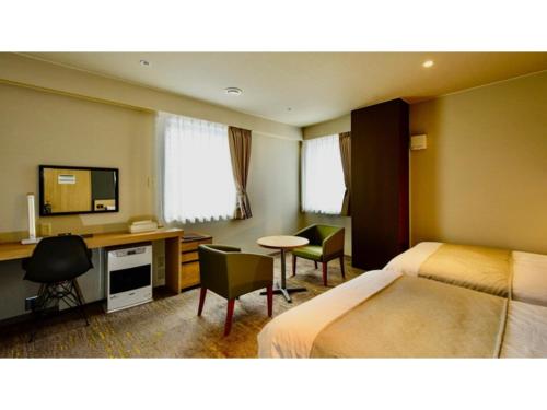 um quarto de hotel com duas camas e uma secretária em Hotel Three M - Vacation STAY 93392v em Kutchan