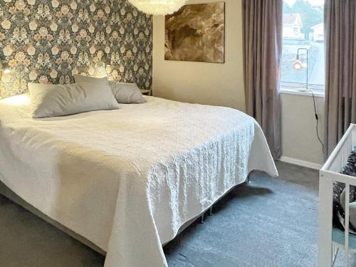 ein Schlafzimmer mit einem Bett mit einer weißen Decke und einem Fenster in der Unterkunft Holiday home VÄSTERVIK III in Västervik
