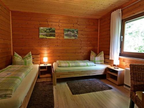 1 dormitorio con 2 camas en una cabaña de madera en Appealing apartment in Grafenau en Haus im Wald