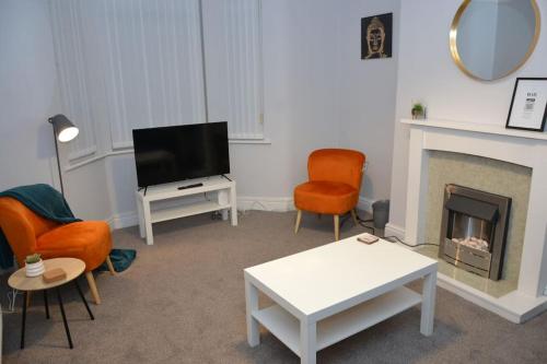 a living room with a tv and a fireplace at Salisbury - New 3br home, wifi, parking, sleeps 6, near Liverpool city centre in Birkenhead