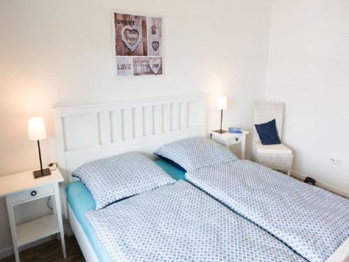a white bedroom with a bed and two pillows at Holiday apartment Ross in Eslohe
