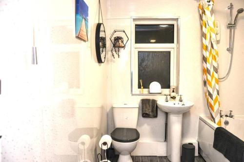a small bathroom with a toilet and a sink at Salisbury - New 3br home, wifi, parking, sleeps 6, near Liverpool city centre in Birkenhead