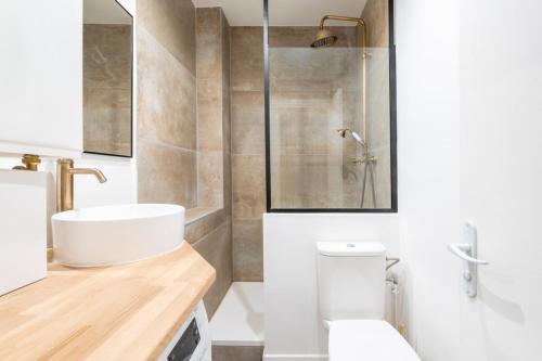 une salle de bain avec un lavabo, des toilettes et une douche dans l'établissement Beautiful Modern Studio Apartment Belleville, à Paris