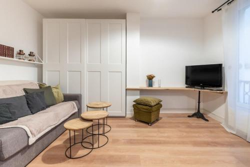 - un salon avec un canapé et deux tabourets dans l'établissement Beautiful Modern Studio Apartment Belleville, à Paris