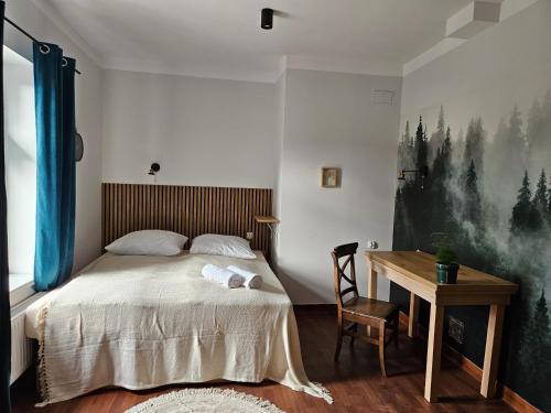a bedroom with a bed and a desk and a table at Dworek Szumilas in Prudnik