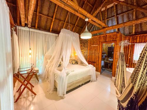 Schlafzimmer mit einem Bett mit Moskitonetz in der Unterkunft Ecohabs Bamboo Parque Tayrona - Dentro del PNN Tayrona in El Zaino
