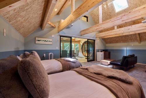 two beds in a room with wooden ceilings at GRAN TOCORO, RESORT&GLAMPING - Vacation STAY 84972v in Narusawa