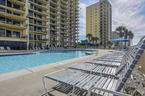 a swimming pool with lounge chairs and a building at Phoenix 6 Unit 408 in Orange Beach