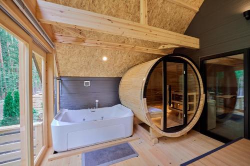 a bathroom with a tub and a round mirror at GRAN TOCORO, RESORT&GLAMPING - Vacation STAY 84990v in Narusawa