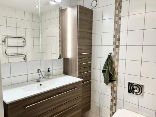 a white tiled bathroom with a sink and a shower at Mailatunet - Vestlia resort in Geilo