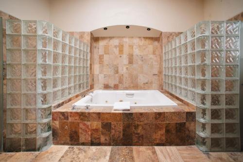 a bath tub in a room with tile walls at Hotel Casa Antigua in Oaxaca City