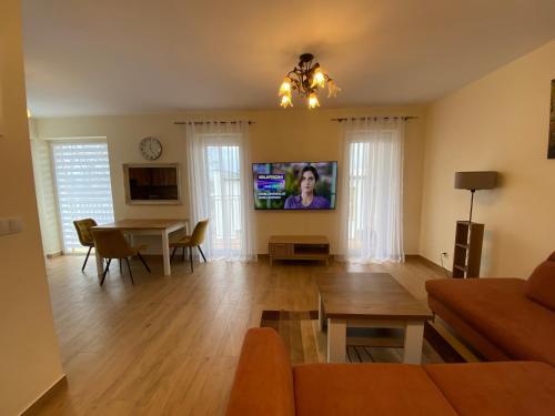 een woonkamer met een tafel en een televisie bij Apartament na Zielonym Wzgórzu in Bielsko-Biala