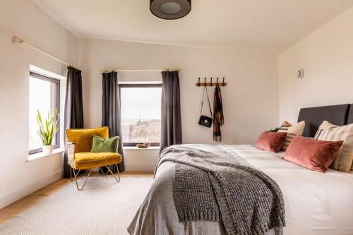 a bedroom with a bed and a yellow chair at Stunning 5 Bedroom New Build with Amazing Views! in Bath