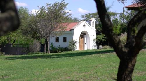 a small white chapel with a red roof at Casa golf en las sierras de Cordoba in Cordoba