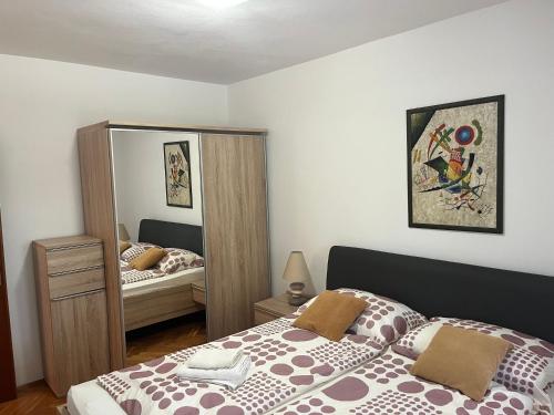 een slaapkamer met een bed en een grote spiegel bij Elena relax for 4 in Rabac
