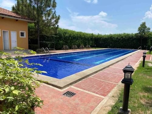 a swimming pool in a yard next to a house at Transient House Orani in Orani