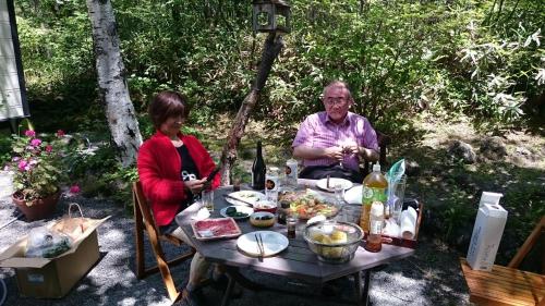 a man and a woman sitting at a table with food at Karuizawa Villa Etoile - Vacation STAY 15095 in Kita-karuizawa