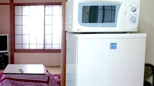 a microwave sitting on top of a refrigerator at Cottage Karuizawa - Vacation STAY 07556v in Oiwake