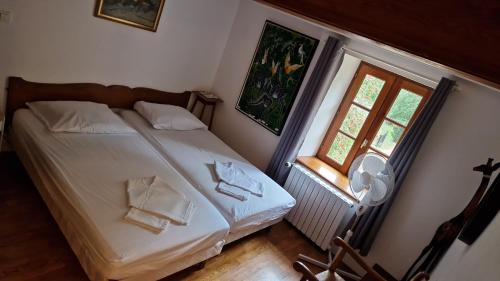 - une chambre avec un lit doté de draps blancs et une fenêtre dans l'établissement MAISON SYLVAIN, à Tournus