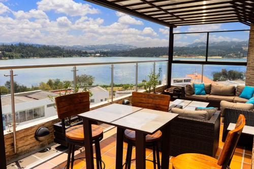 a balcony with a table and chairs and a view of the water at Samakwā Hotel Boutique in Paipa