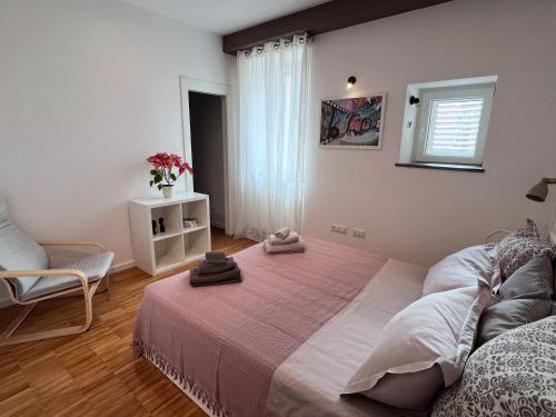 um quarto com uma cama, uma cadeira e uma janela em Central Modern Apartment Near the Beach em Split