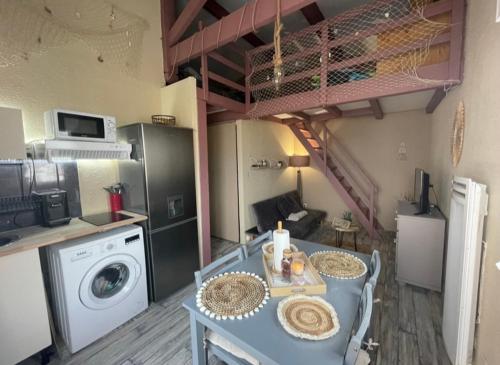 - une cuisine avec une table et un lave-linge/sèche-linge dans l'établissement Appartement Saint Pierre la mer vue Mer, à Fleury
