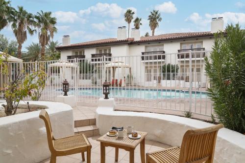 a patio with chairs and a table next to a pool at La Casa Del Zorro Resort & Spa in Borrego Springs