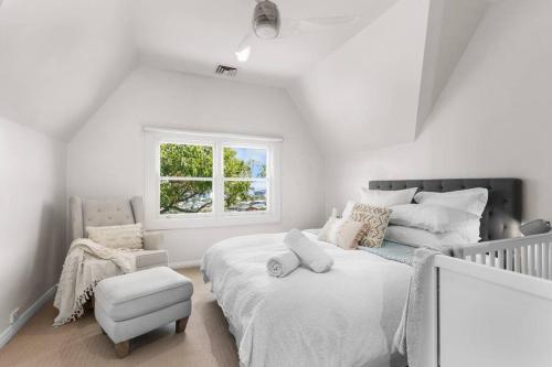 a white bedroom with a large bed and a chair at City Vista's at The Hill in Newcastle