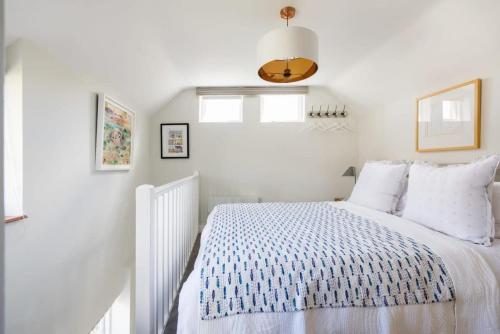 a white bedroom with a bed and a window at The Lavender Folly - Cosy Accommodation Alresford in New Alresford