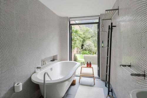 a bathroom with a tub and a shower and a sink at Georgian Townhouse with Sun Terrace & Garden in London